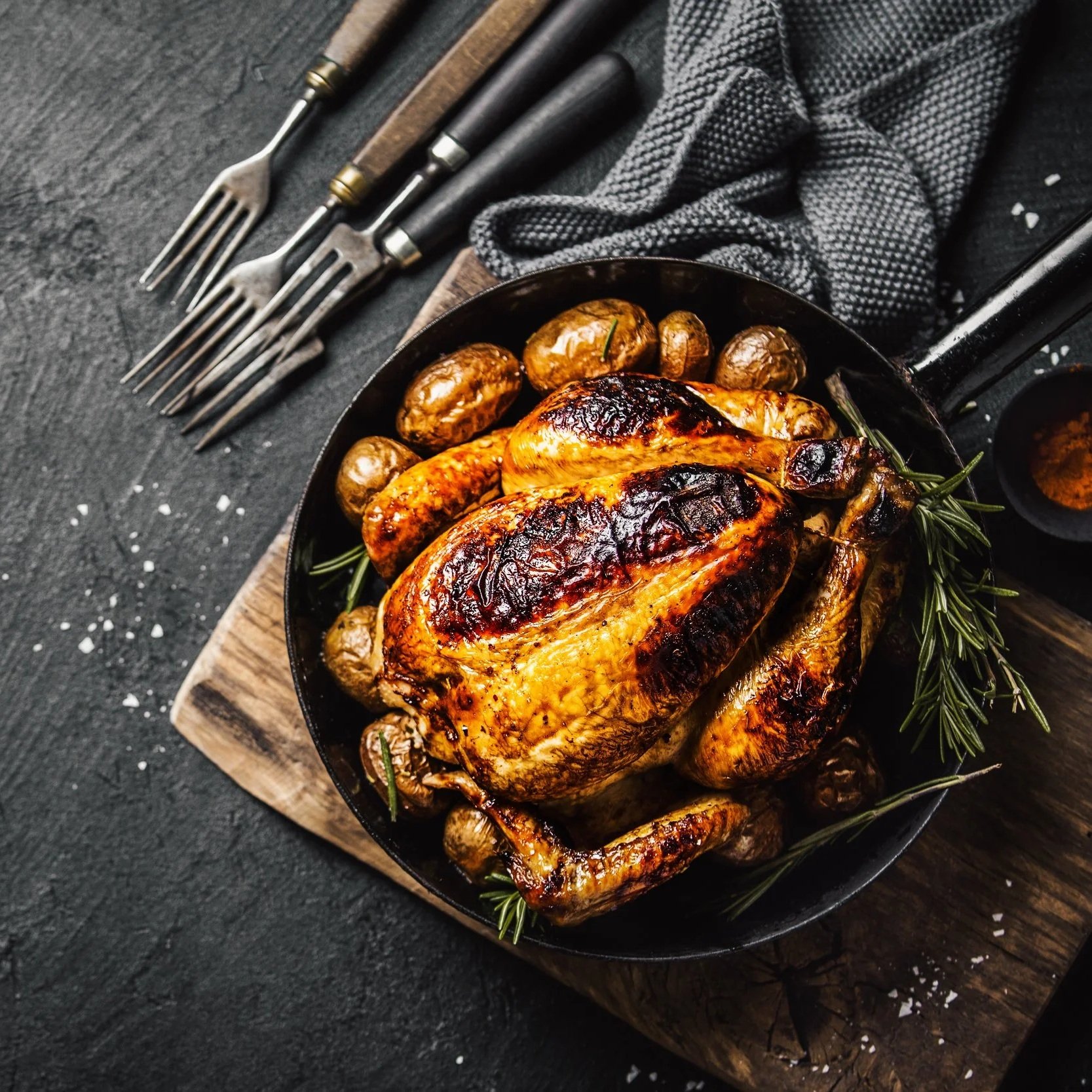 Succulent pulled pork on a wooden cutting board, showcasing tender, shredded meat with a crispy outer layer. A fork rests beside the meat, highlighting its juicy texture and rich seasoning.
